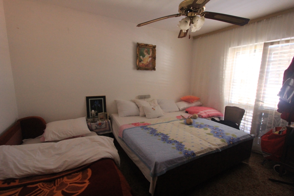Schlafzimmer in einem Haus in Radovici, Montenegro: Doppelbett und Einzelbett, Deckenventilator, helle Wände.
