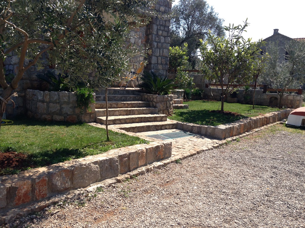 Steinvilla mit Terrasse und Garten in Luštica, Montenegro: Außenansicht des Hauses aus Naturstein mit Landschaftsgestaltung.