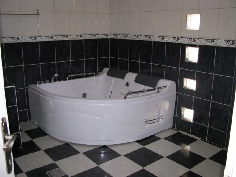 Bathroom with corner jacuzzi and black-and-white tile in a house for sale, Utjeha, Montenegro.