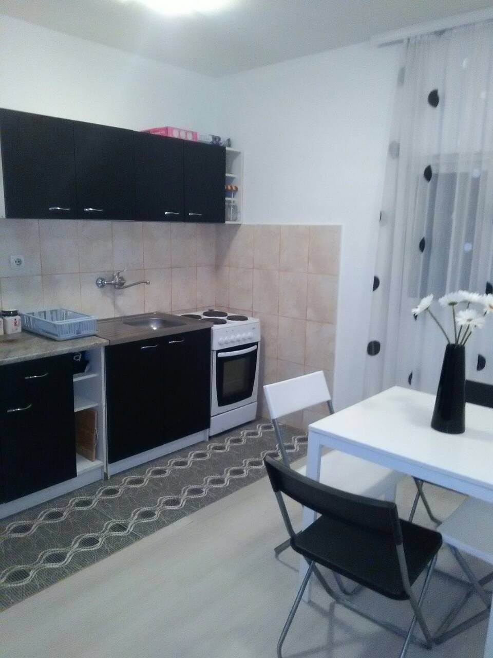 Küche mit schwarzer Einbauküche und Essbereich im Haus, Šušanj, Montenegro. Helles Interieur mit moderner Ausstattung.