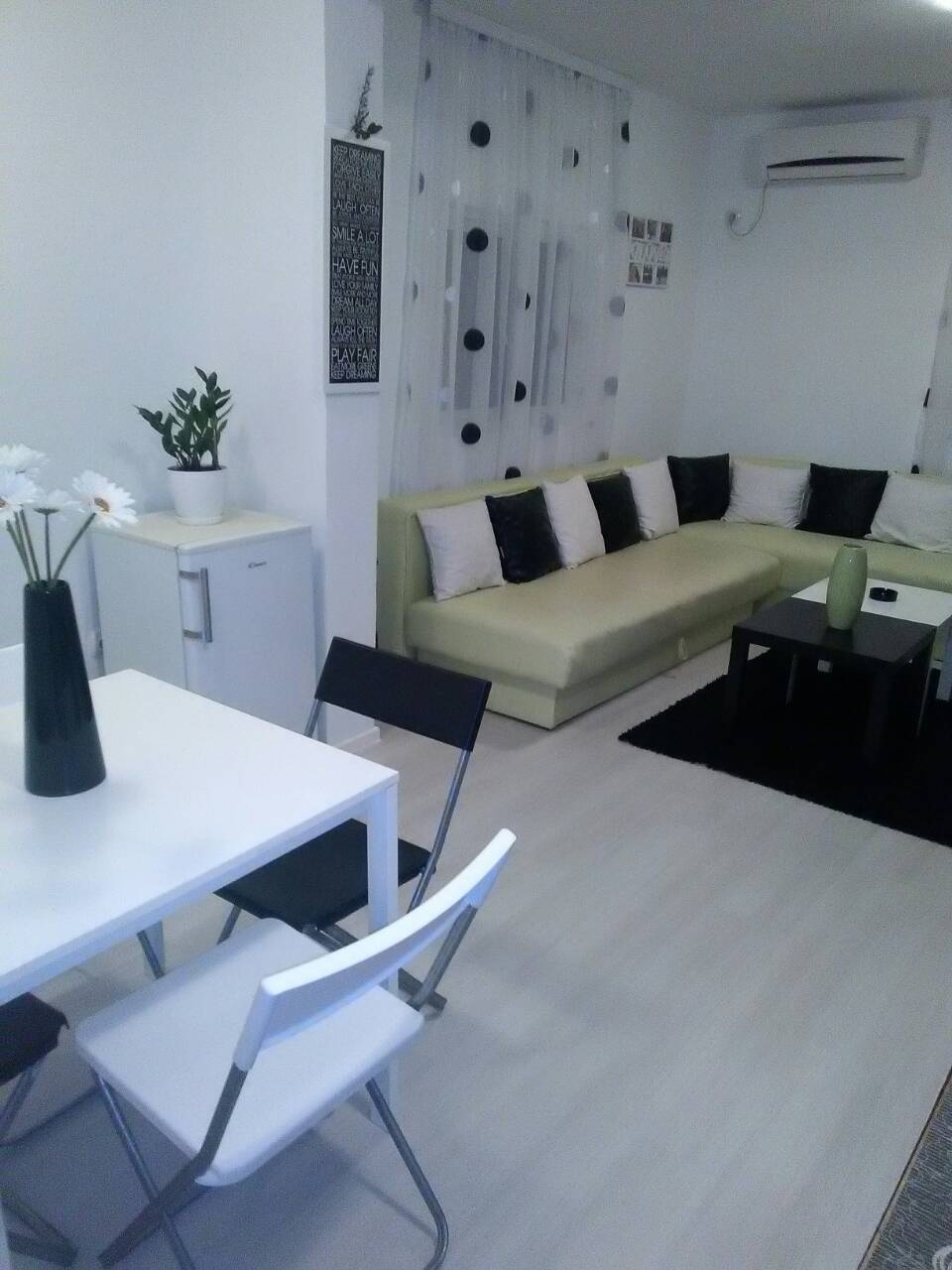 Helles Wohnzimmer mit Ecksofa und Essbereich in einem Haus, Šušanj, Montenegro. Modernes Interieur mit Klimaanlage.