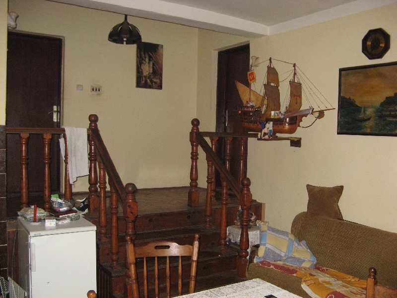 Wohnzimmer in einem Haus in Šušanj, Montenegro: Holztreppe, Polstermöbel, Dekor mit Segelschiff und klassische Ausstattung.