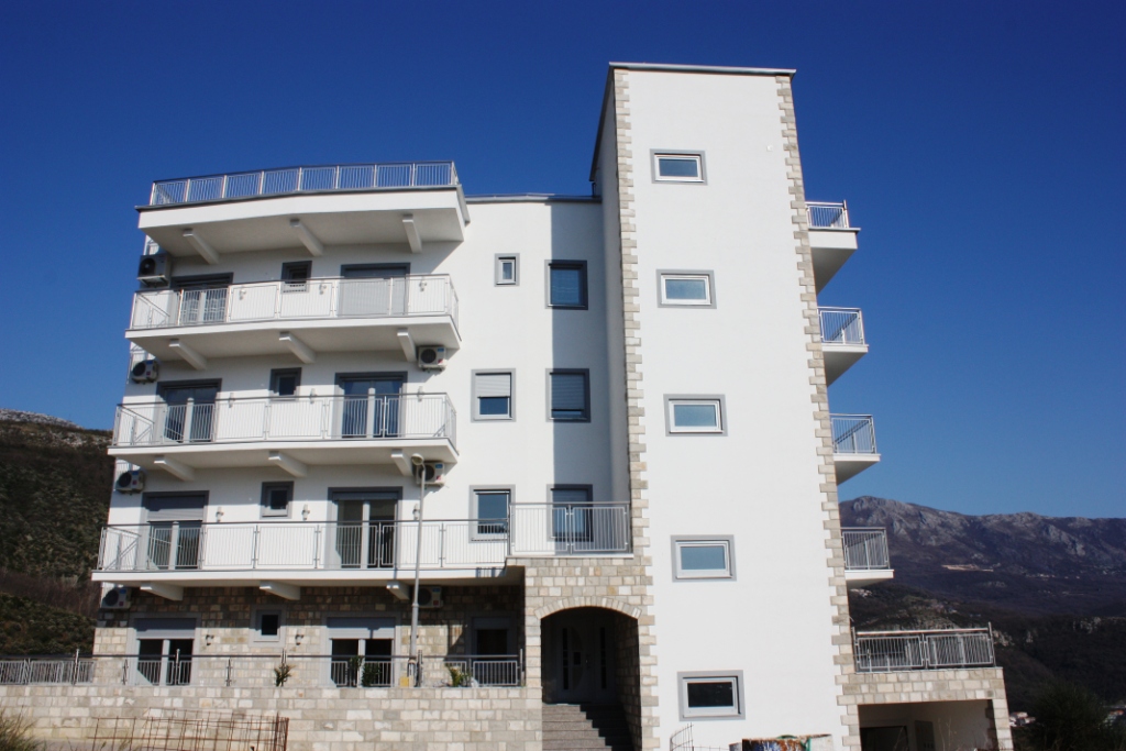 Becici, Karadağ’da balkonlu ve taş cephe kaplamalı modern çok daireli bina.