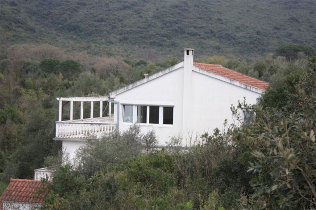 Weißes Haus mit Terrasse und Ziegeldach inmitten von Grün, Immobilienverkauf in Bigovo, Montenegro.