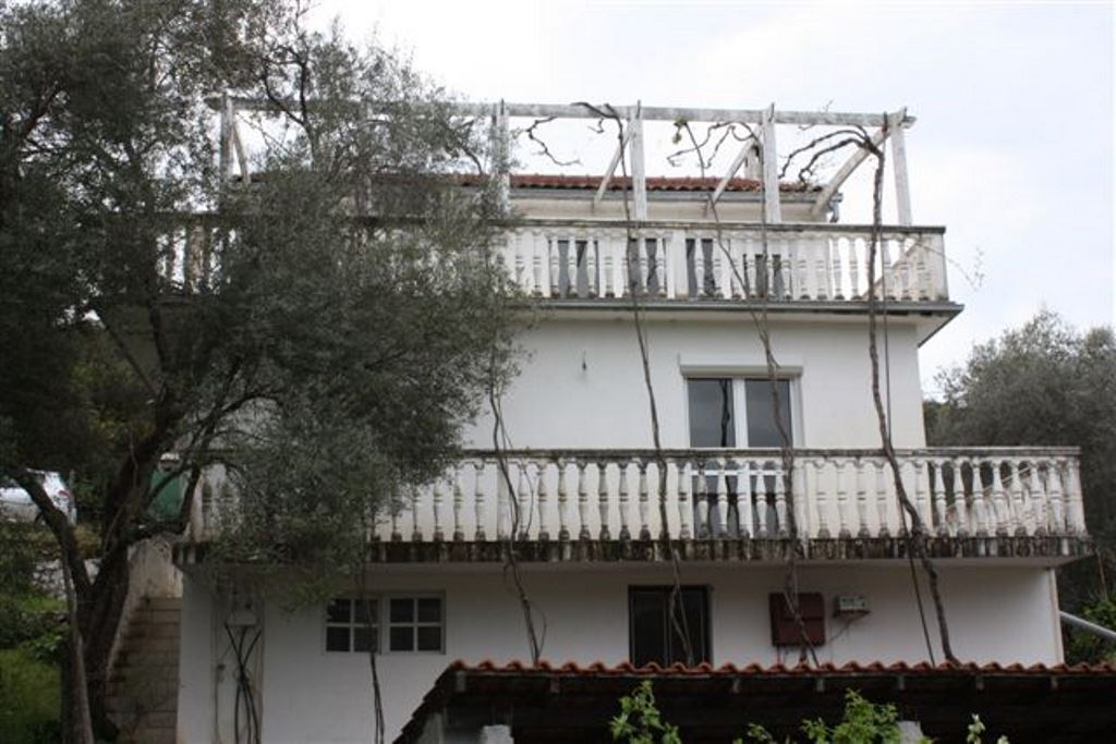 Zweistöckiges Haus mit Terrassen und Weinrebe im Dorf Bigovo, Montenegro, Blick auf die Fassade des Gebäudes.