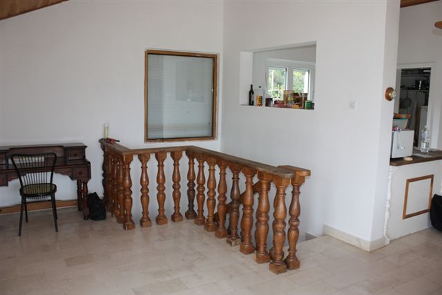 Innenansicht des Wohnzimmers mit Holztreppe und antikem Tisch in einem Haus zum Verkauf, Bigovo, Montenegro.