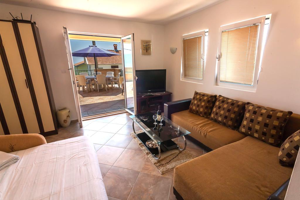 Wohnzimmer mit weichem Sofa und Zugang zur Terrasse im Haus, Krimovica, Montenegro. Helles Interieur mit Möbeln.
