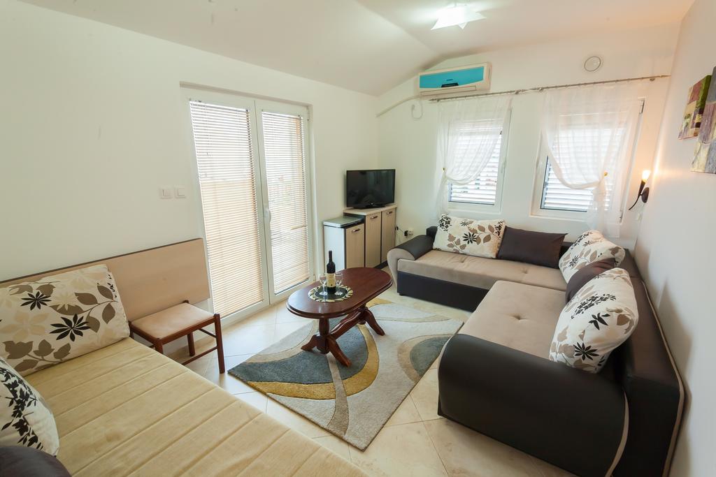 Gemütliches Wohnzimmer mit Sofaecke und TV in einem Haus zum Verkauf, Krymovica, Montenegro: helles Interieur, Fliesenboden.