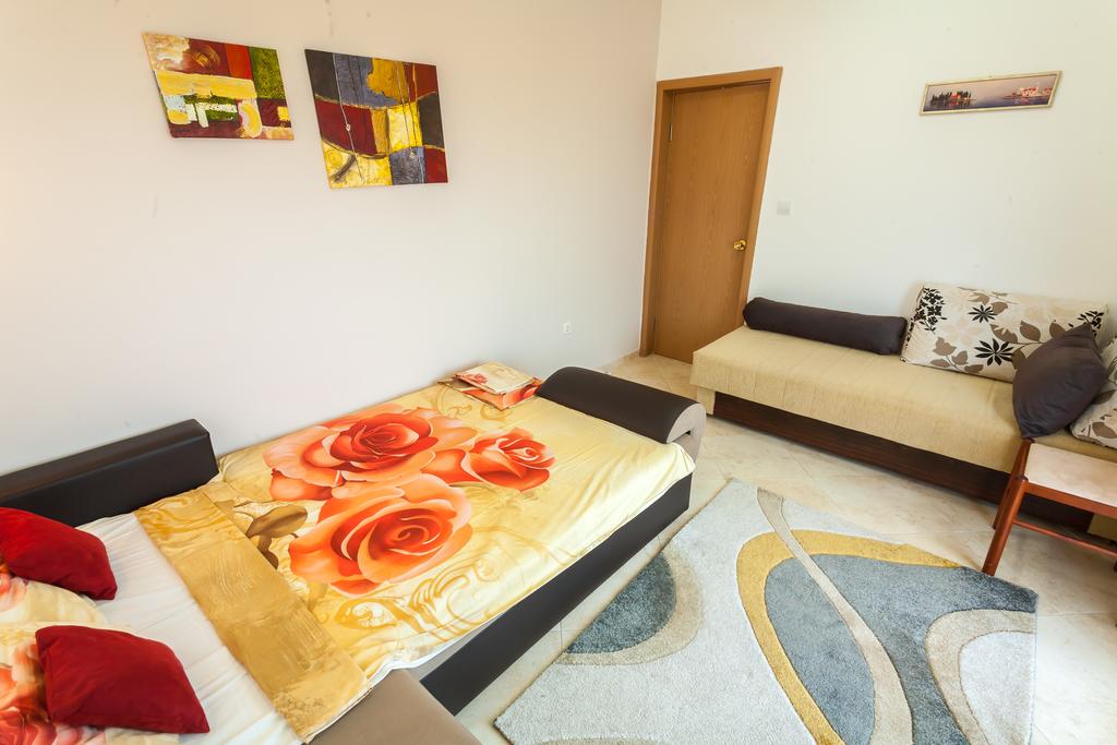 Wohnzimmer mit zwei Sofas und Teppich in einem Haus zum Verkauf in Krymowice, Montenegro. Heller Innenraum mit Bildern an den Wänden.