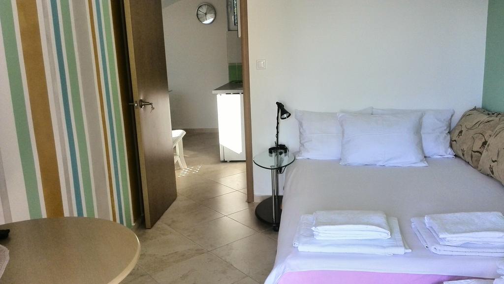Gemütliches Schlafzimmer mit Doppelbett in einem Haus in Krymovice, Montenegro: helles Interieur, Fliesenboden und Blick auf die Küche.