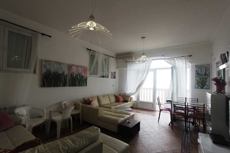 Wohnzimmer mit Ledersofa und Zugang zur Terrasse in einer Wohnung, Sveti Stefan, Montenegro. Helles Interieur mit Meerblick.