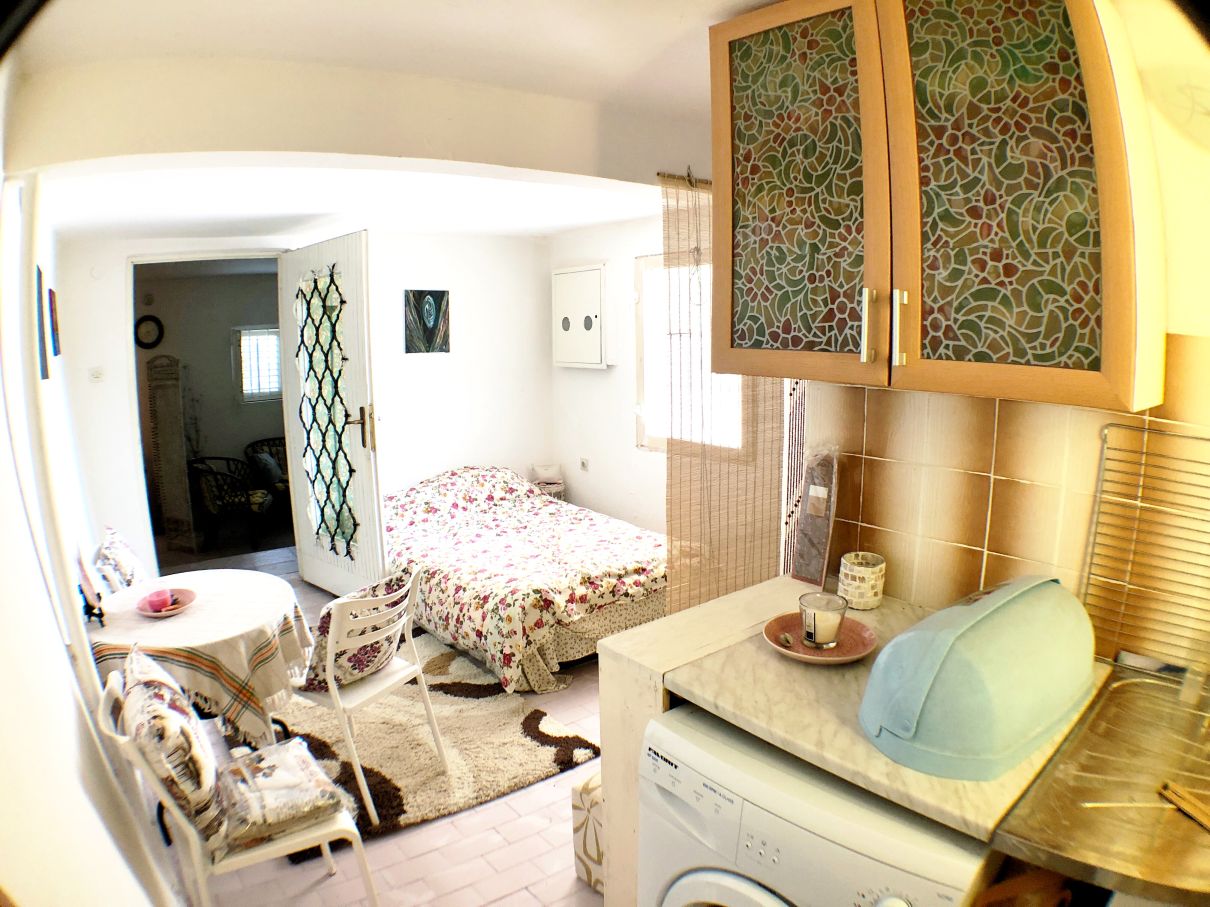 Living room interior with kitchen in a house in Risan, Montenegro: dining area, double bed, and kitchen set.