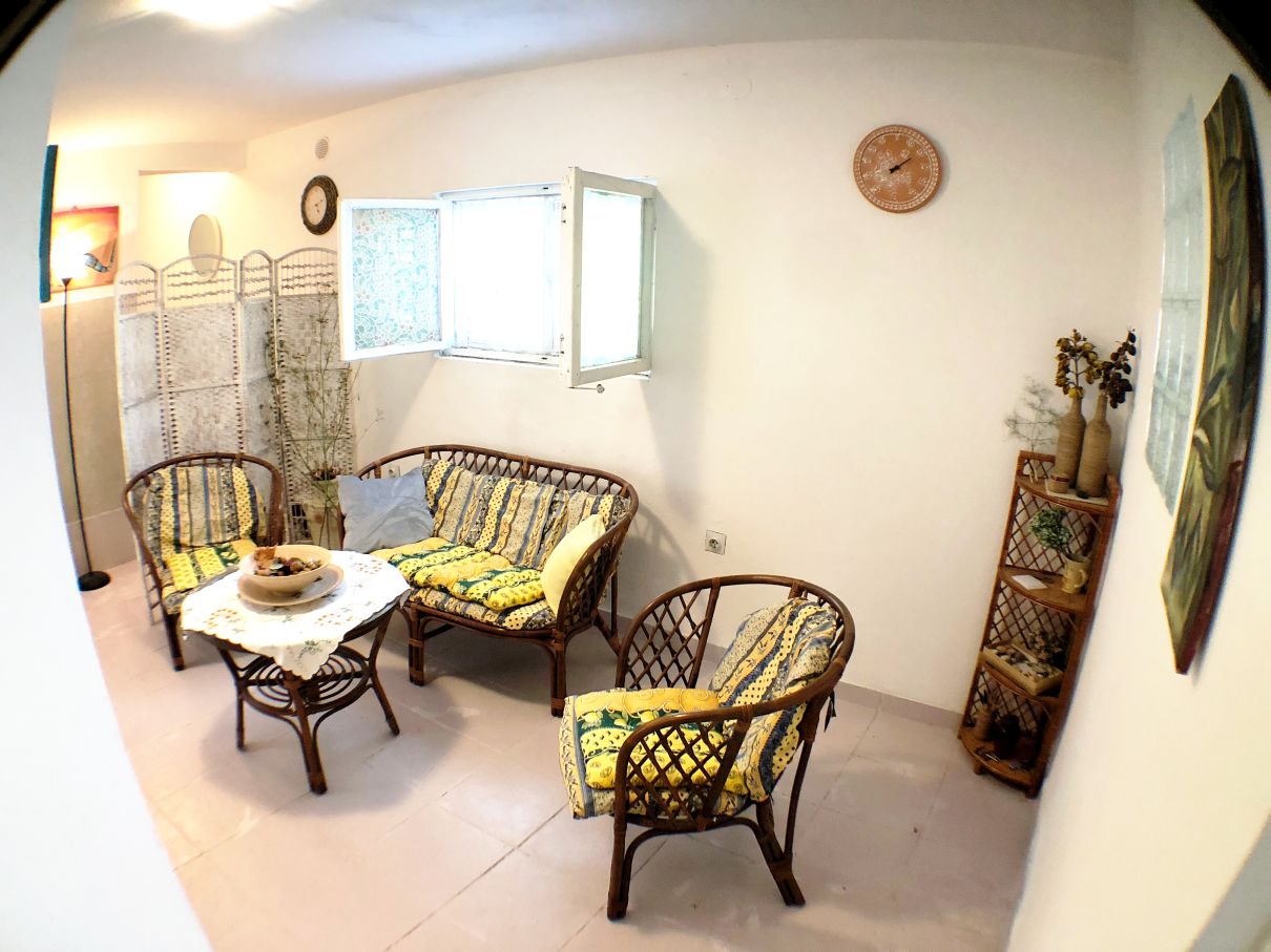Cozy living room with wicker furniture in a house for sale in Risan, Montenegro: bright interior and decor.