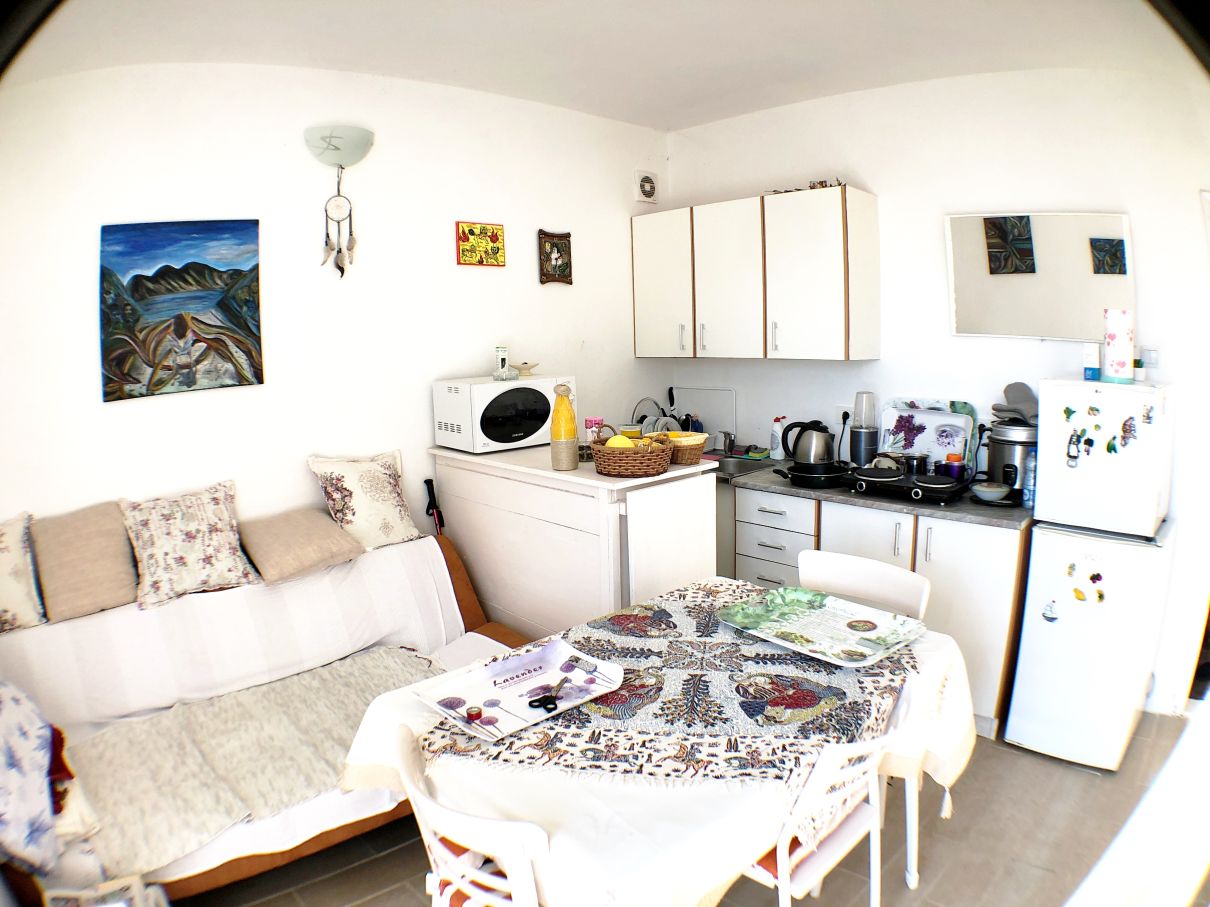 Kitchen-living room with dining area and light-colored furniture in a house for sale in Risan, Montenegro.