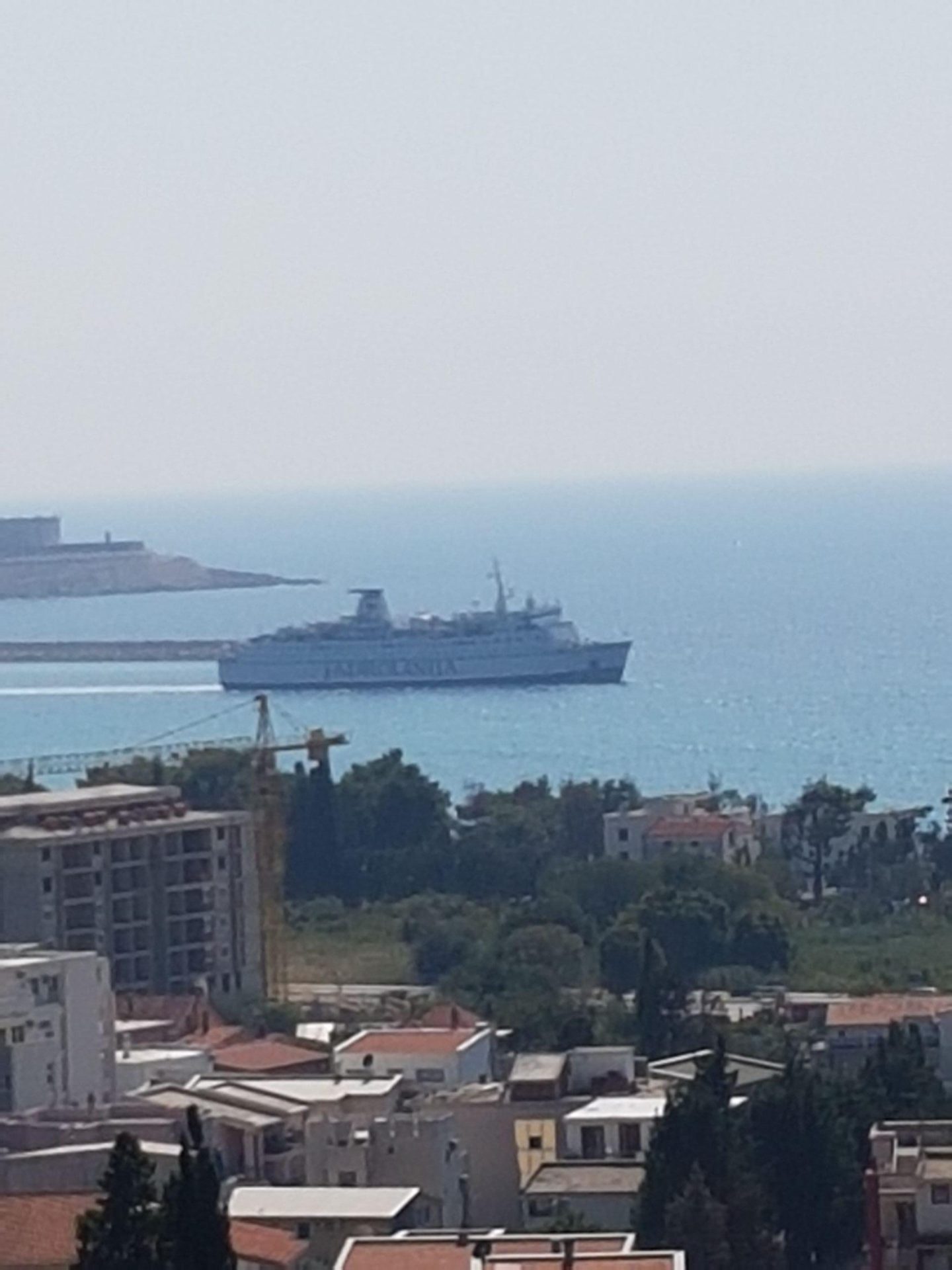 Panoramablick auf das Meer und ein Kreuzfahrtschiff vom Haus in Šušanj, Montenegro, mit Blick auf die städtische Bebauung.