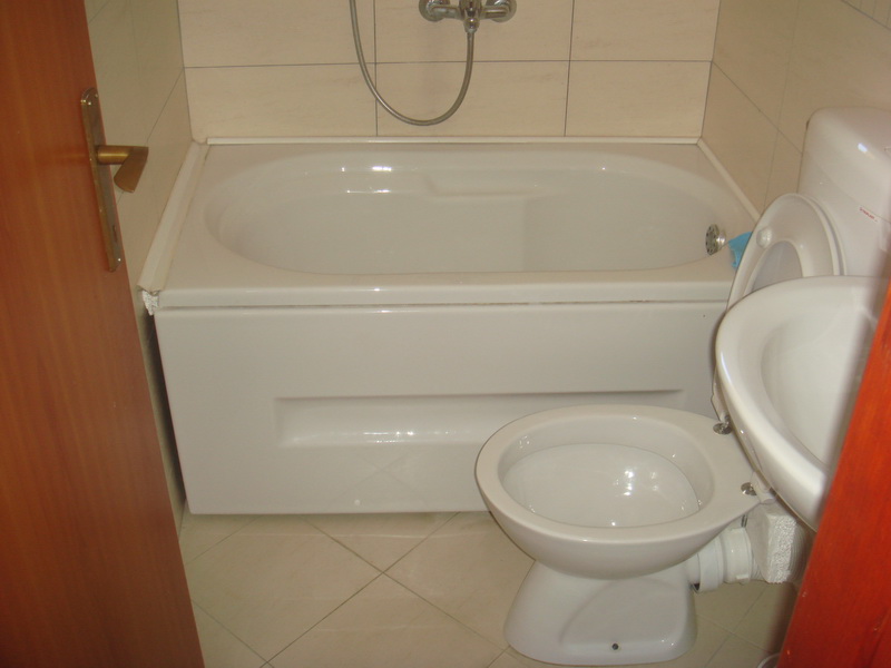 Badezimmer in einem Haus in Šušanj, Montenegro: weiße Badewanne, Sanitäranlagen und helle Fliesen im Interieur von Haus Nr. 577.