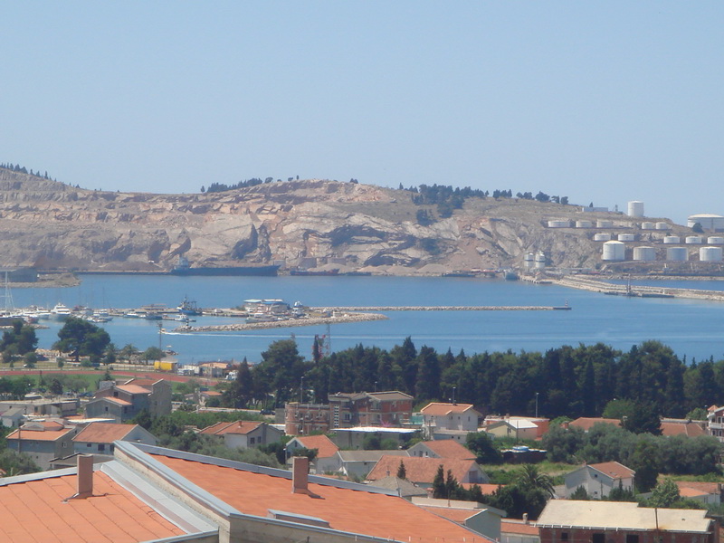 Panoramablick auf das Meer, den Hafen und die Berge vom Haus in Šušanj, Montenegro: Ziegeldächer und Meereslandschaft.
