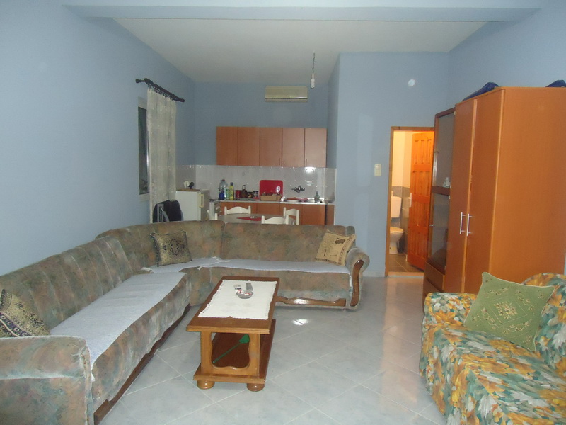 Wohnzimmer mit Polstermöbeln und Küche in einem Haus zum Verkauf, Shushan, Montenegro: Innenraum mit Sofa und Essbereich.