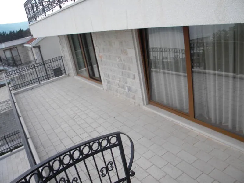 Geräumige Terrasse einer Villa in Herceg Novi, Montenegro, mit Steinverkleidung, Panoramafenstern und schmiedeeisernem Geländer.