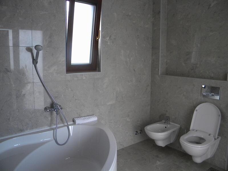 Modern bathroom with gray stone finishes, a bathtub, and fixtures in a villa in Herceg Novi, Montenegro.