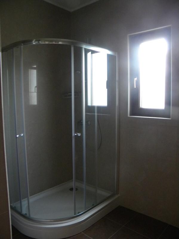 Modern bathroom with a shower cabin in a villa, Herceg Novi, Montenegro: stylish finishes and a window.