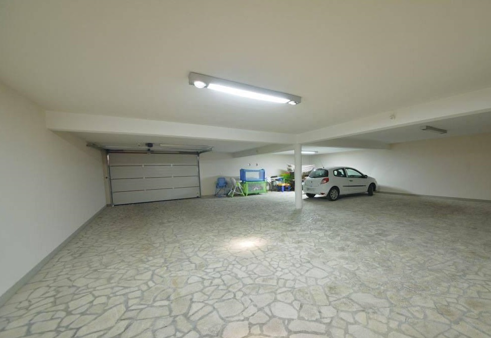 Spacious covered garage with a stone floor and automatic gates at a villa in Herceg Novi, Montenegro.