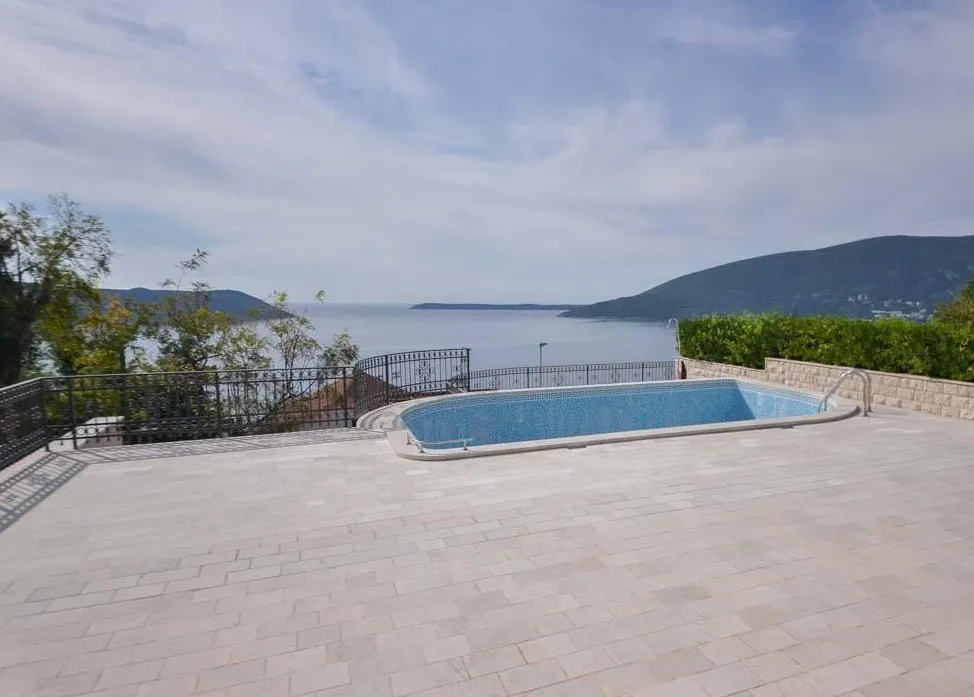 Offener Pool auf der Terrasse einer Villa in Herceg Novi, Montenegro, mit Panoramablick auf die Adria und die Berge.