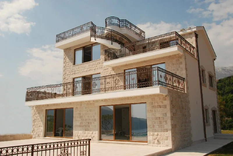 Dreistöckige Steinvilla mit Terrassen und schmiedeeisernen Geländern in Herceg Novi, Montenegro. Blick auf die Fassade des Hauses.