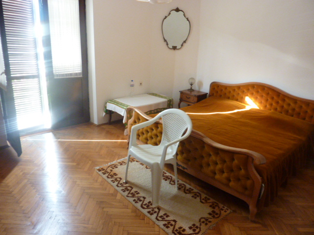 Schlafzimmer mit Doppelbett, Parkett und Zugang zur Terrasse in einem Haus, Kumbor, Montenegro.