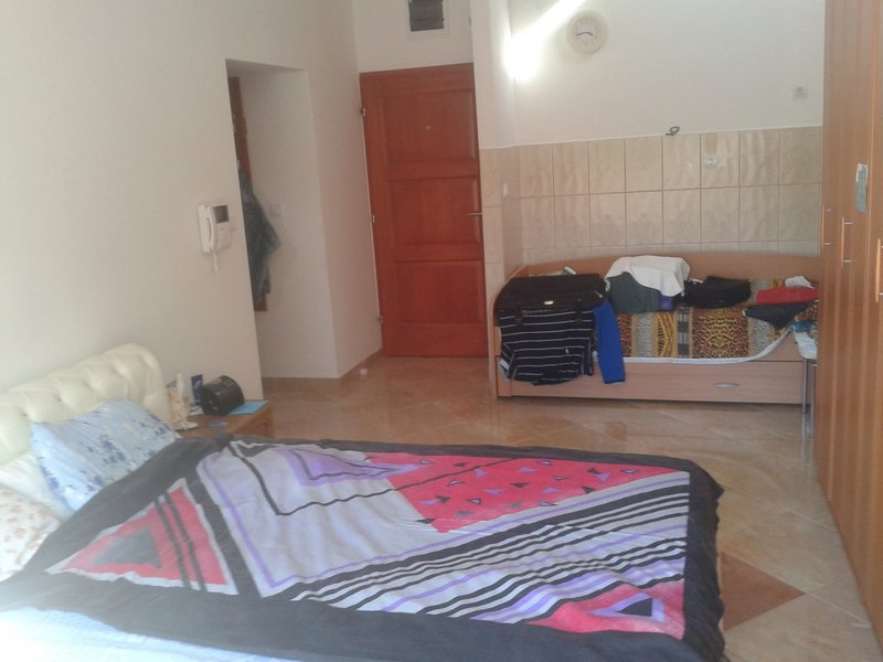 Schlafzimmer in einer Wohnung in Igalo, Montenegro: Doppelbett, zusätzliche Liege, Kleiderschrank und Fliesenboden.