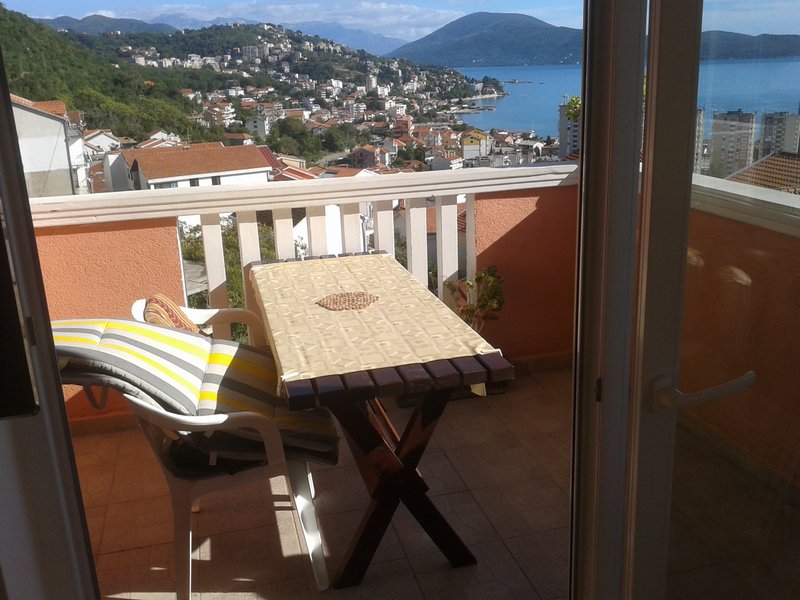 Balkon mit Möbeln und Panoramablick auf das Meer und die Stadt Igalo, Montenegro. Wohnung Nr. 563 mit Terrasse und Blick auf die Bucht.