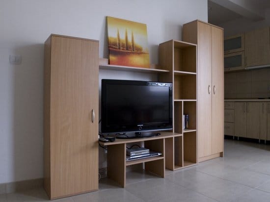 Living room with a wood-look wall unit and TV in an apartment for sale, Zelenika, Montenegro.