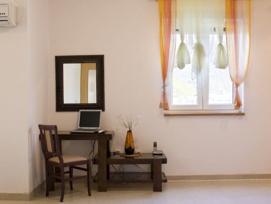 Work area with a wooden desk and mirror in the living room of an apartment in Zelenika, Montenegro.