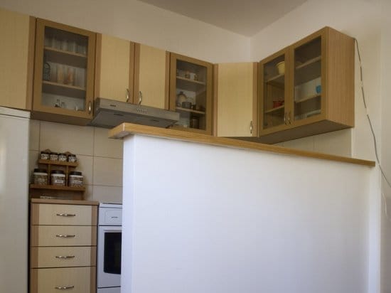 Bright kitchen with wooden fronts and a breakfast bar in an apartment for sale, Zelenika, Montenegro.