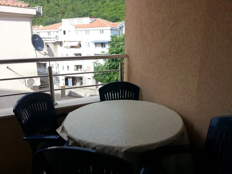 Gemütlicher Balkon mit Essbereich in der Wohnung, Budva, Montenegro: Blick auf die Stadt und die Berge, Kunststoffmöbel.