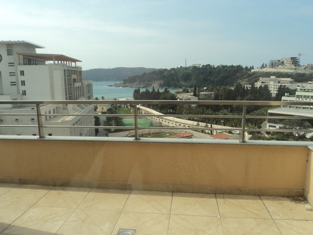 Blick vom Balkon der Wohnung in Bečići, Montenegro: Panorama auf das Meer, die Berge und die Ferieninfrastruktur mit Tennisplatz.