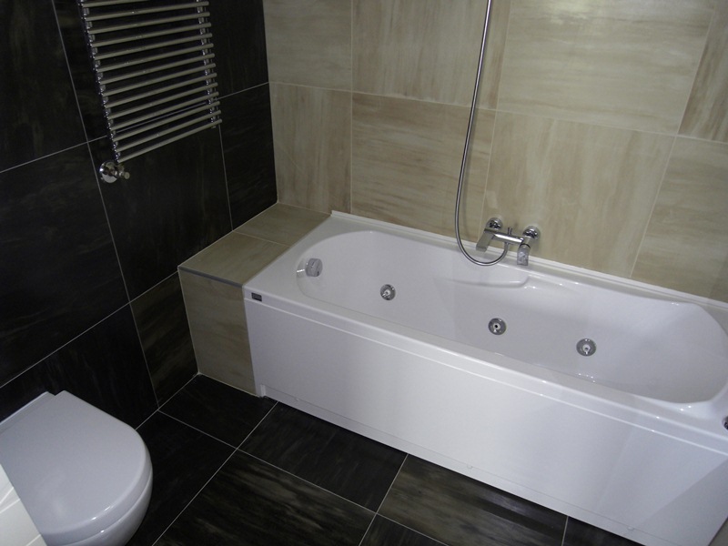 Modernes Badezimmer mit Whirlpool und Fliesenverkleidung in einer Wohnung in Budva, Montenegro.