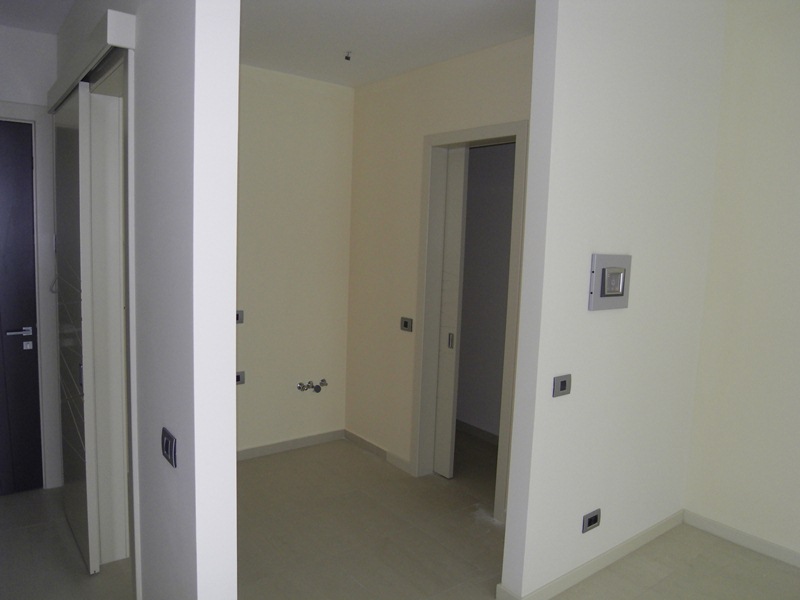 Innenraum einer modernen Wohnung in Budva, Montenegro: helle Wandverkleidung, Innentüren und Anschlüsse für Sanitärinstallationen.