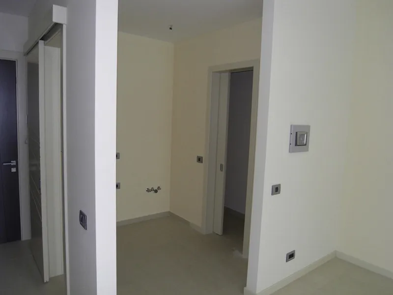 Ein Flur in einer Wohnung mit offenen Türen und hellen Wänden.