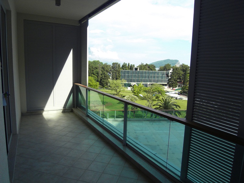 Geräumiger Balkon mit Panoramablick auf den Park und die Berge in einer Wohnung in Budva, Montenegro, mit moderner Ausstattung.