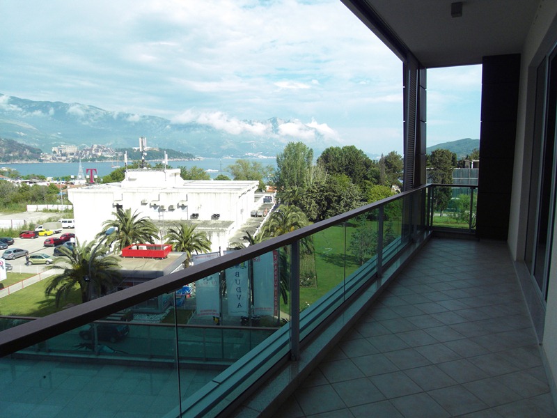 Geräumiger Balkon mit Panoramablick auf das Meer und die Berge in einer Wohnung in Budva, Montenegro, mit moderner Fliesenverkleidung.