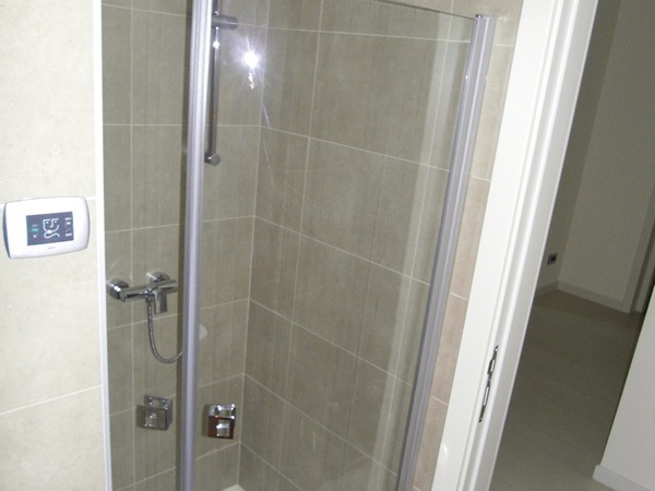 Moderne Duschkabine mit beigen Fliesen im Badezimmer einer Wohnung in Budva, Montenegro.
