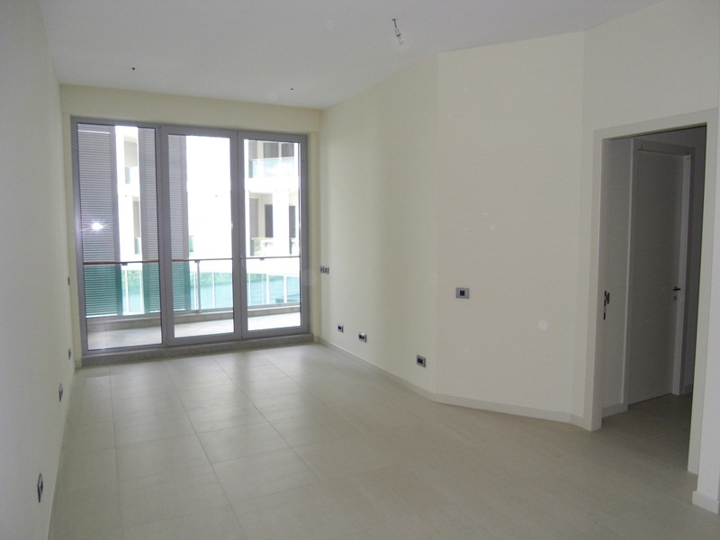 Helles Wohnzimmer mit Panoramafenstern und Zugang zum Balkon in einer neuen Wohnung, Budva, Montenegro.