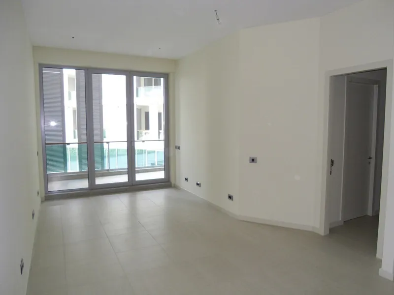 Helles Wohnzimmer mit Panoramafenstern und Zugang zum Balkon in einer neuen Wohnung, Budva, Montenegro.