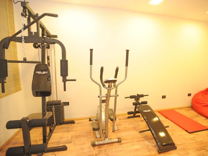 Home gym with a strength training station and elliptical in a villa in Bigovo, Montenegro: modern sports equipment.