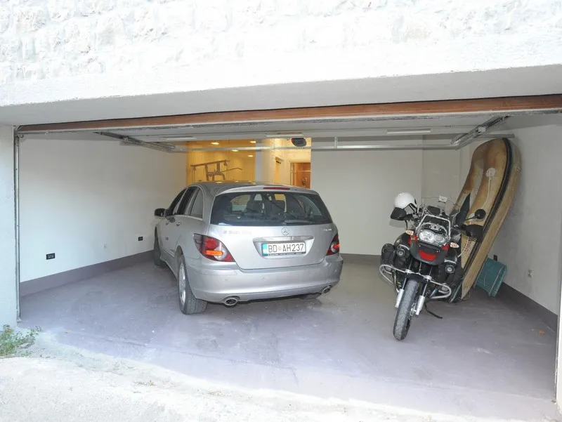 Spacious garage at a villa in Bigovo, Montenegro, with space for a car, motorcycle, and sports equipment.