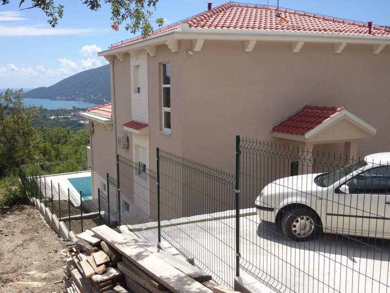 Dvospratna kuća sa bazenom i pogledom na more u Herceg Novom, Crna Gora: fasada sa krovom od crepova i parking.