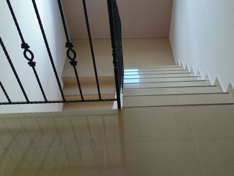 Stepenište sa kovanom ogradom i oblogom od bež pločica u kući, Herceg Novi, Crna Gora.