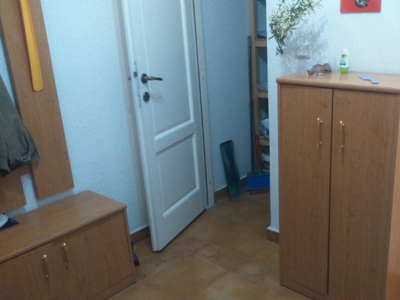 Flur mit Holzmöbeln und heller Tür in einer zum Verkauf stehenden Wohnung in Budva, Montenegro.