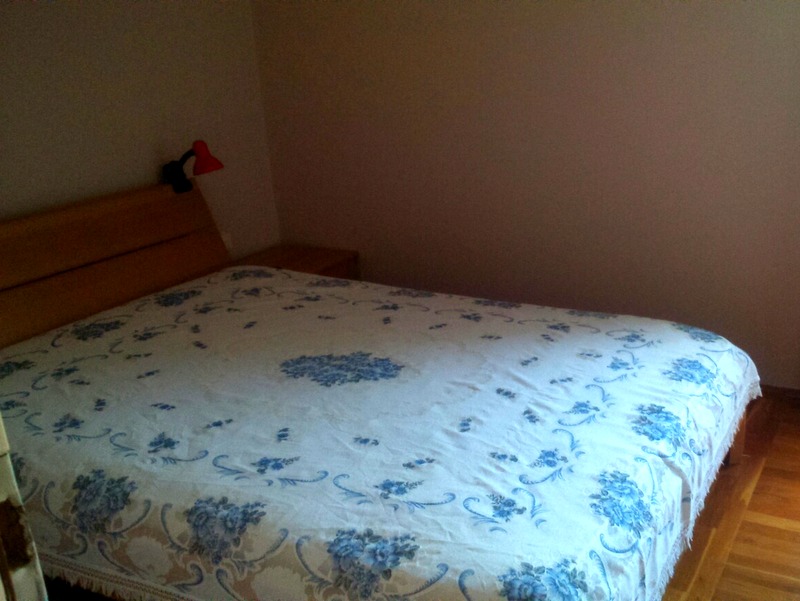 Schlafzimmer mit Doppelbett und Holz-Kopfteil in einer Wohnung, Budva, Montenegro.